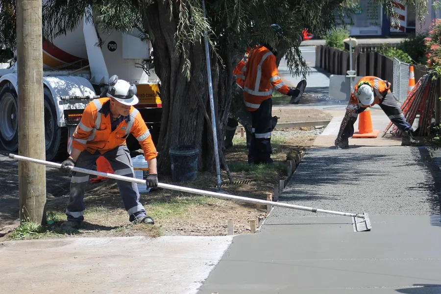 Concrete crew screeding a freshly poured slab next to a ready-mix truck, Bartlesville